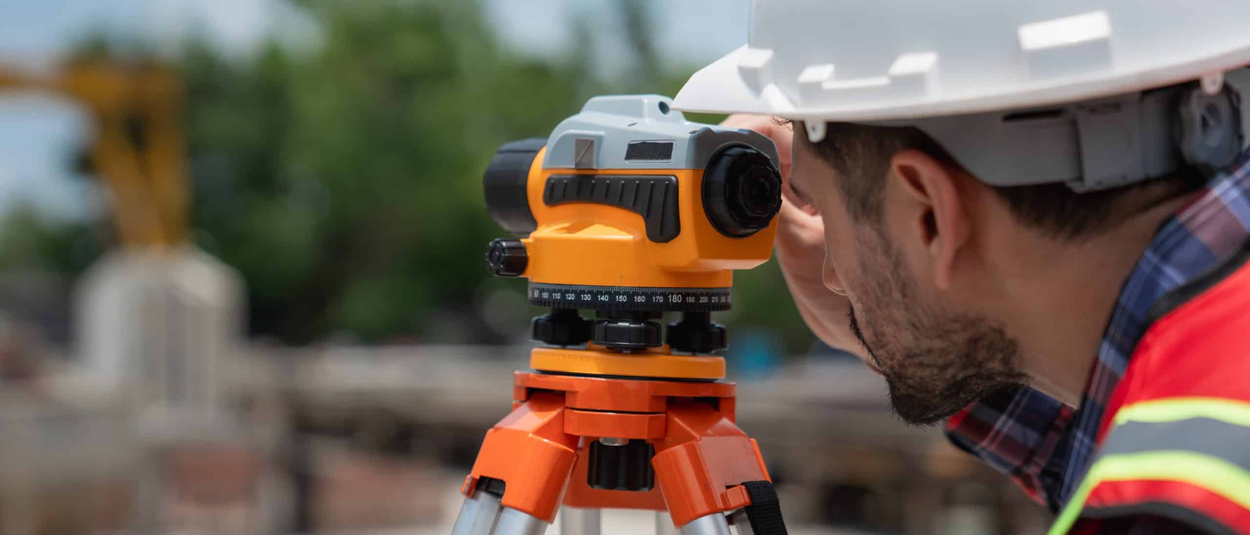 a man looking at a level on a tripod