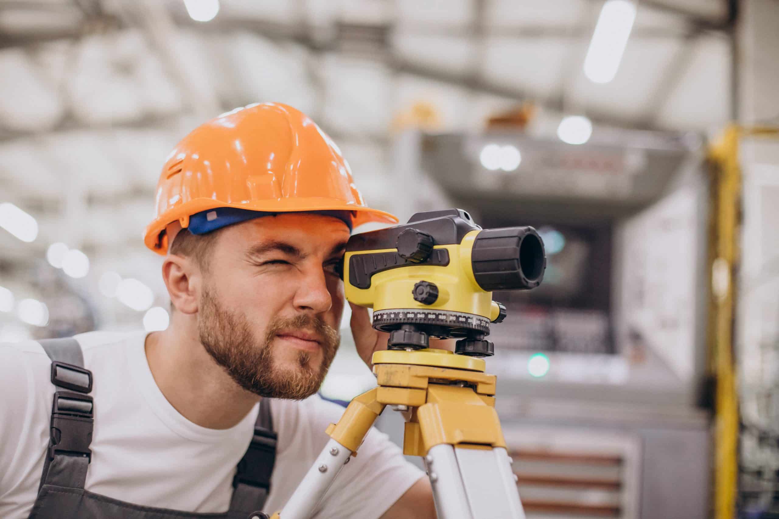 a man wearing a hard hat and looking at a level