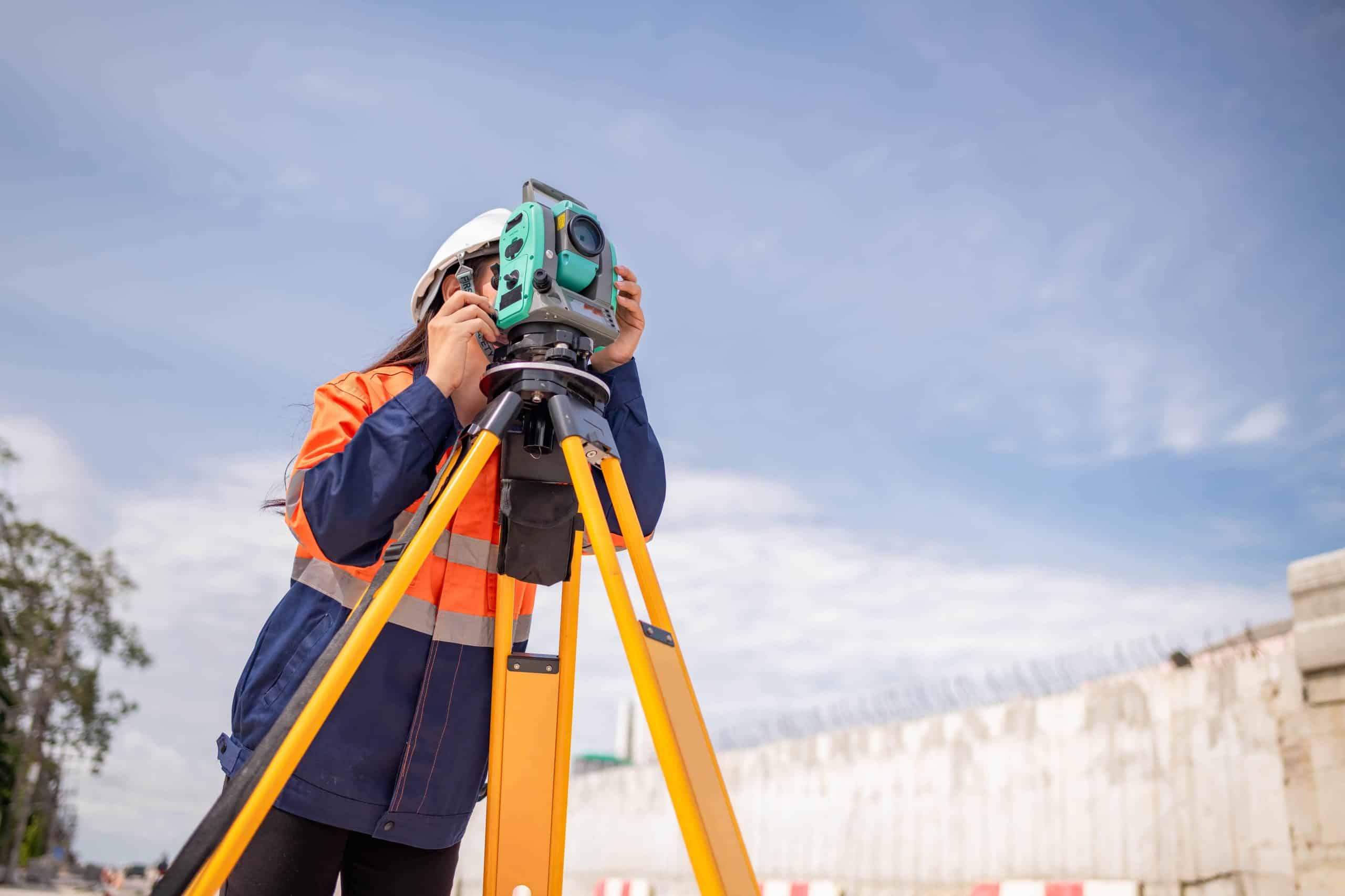 a woman using a theodolite on a tripod